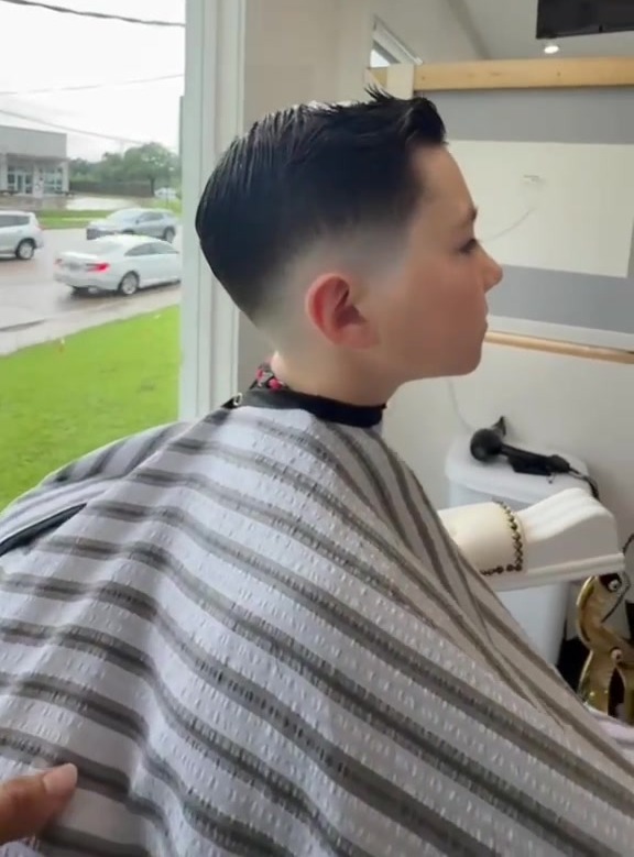 A young client's fresh tapered haircut, viewed from the side.