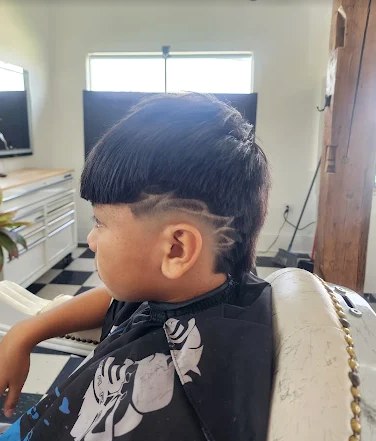 A young client's fresh fade, viewed from the side, freshly finished.